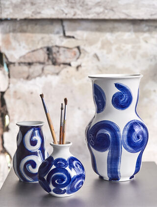 Die Tulle Vasenserie von Kähler Design stellt eine exquisite Kombination aus Kunst und Handwerk dar. In den nuancierten Blau-Weiss Tönen handbemalt, zeichnet sich jedes Stück durch kreisförmige und verschnörkelte Muster aus, die eine zeitlose Eleganz verkörpern. Die Nulle-Serie ist eine Hommage an die renommierten Designerin Tulle Emborg und spiegelt den Sinn für traditionelle Handwerkskunst mit einem modernen Touch wider. Die Vasen sind in drei sorgfältig ausgewählten Größen verfügbar: 10 cm, 12,5 cm und 22 cm, um sowohl subtile Akzente als auch markante Statements in jedem Raum setzen zu können.