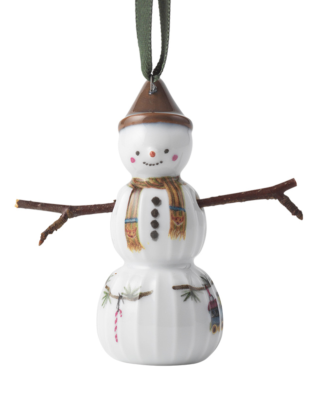 Hammershøi Christmas Schneejunge mit Schal von Kähler Design. Diese Schneemann-Figur trägt einen braunen Hut und einen Schal. Die Figur hat einen runden Kopf mit einem freundlichen Gesichtsausdruck, der durch rosige Wangen betont wird. Die Arme sind ebenfalls aus Zweigen gefertigt. Der Körper ist rundlich mit einem leicht ausgestellten unteren Teil. Auf dem Körper sind ebenfalls dezente, weihnachtliche Motive abgebildet.