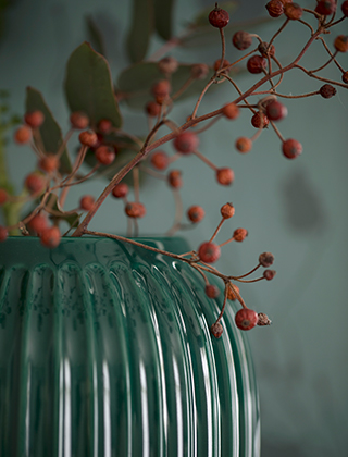 Hammershøi Vase in der mittleren Größe im tiefen Grün von Kähler Design kontrastiert wunderbar mit kräftigen Blumenfarben in Rot und Gelb.