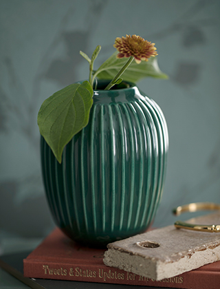 In der kleinsten Hammershøi Vase in Tiefgrün von Kähler Design passen einzelne Blumen und Blüten sowie kleine Zweige.