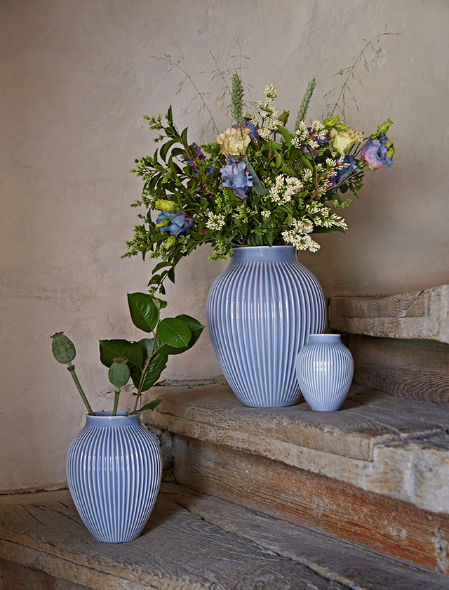 Rillenvasen von Knabstrup in der Farbe Lavendel in den Größen klein, mittel und groß mit Blumen bestückt und stilvoll auf einer Treppe arrangiert.