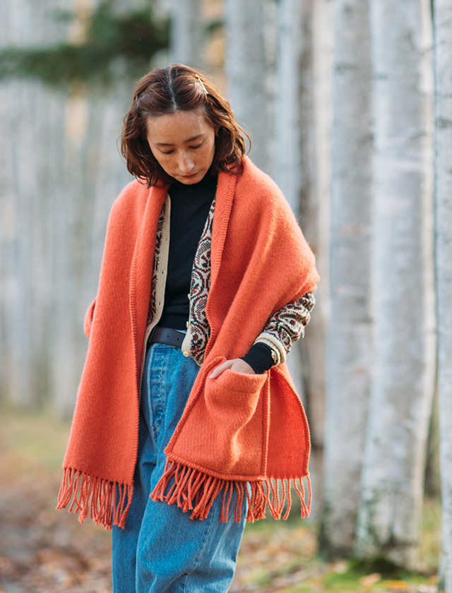 Der aus Finnland stammende Uni Pocket Shawl von Lapuan Kankurit ist ein Poncho mit Taschen, hergestellt aus 100% Schurwolle, in der Farbe Peach.