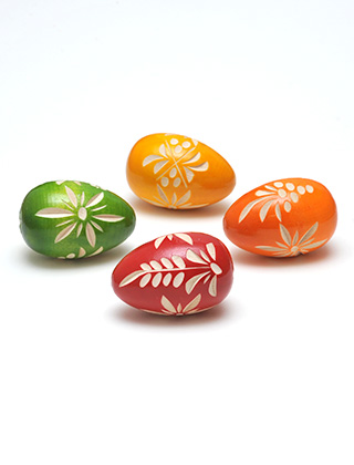Gezeigt werden 4 geschnitzte Holzostereier in den Farben Rot, Orange, Gelb und Grün. In die lackierten Ostereier sind Schnitzereien floraler Ornamente eingearbeitet.